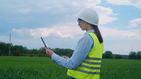 A female engineer stops on the road in front of a high voltage power line, takes Video stock 241801676