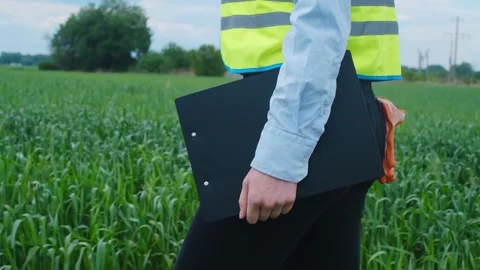 A female engineer stops on the road in front of a high voltage power line, takes Stock Footage 241801782
