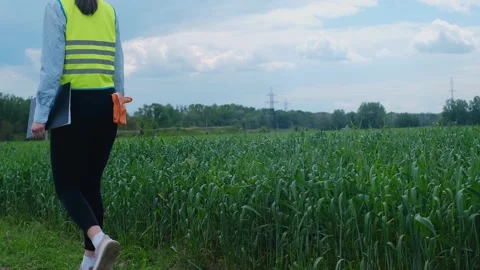A female engineer stops on the road in front of a high voltage power line, takes Stockbeeldmateriaal 241801816
