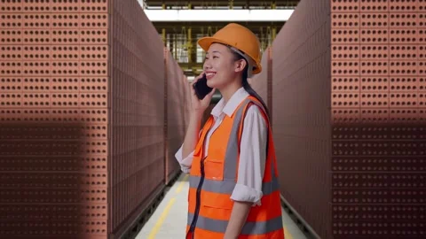 Female Engineer Talking On Smartphone With Brick In Stacks Stock Footage 303762061