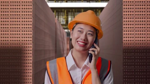 Female Engineer Talking On Smartphone With Brick In Stacks Stock Footage 303762517