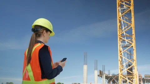 Female Engineer texts on Cell Phone at Construction Site, 4k Stock-Footage 109464155