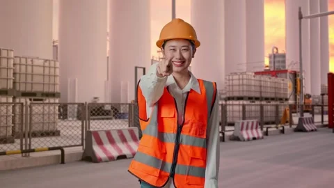 Female Engineer Touching Her Chest Then Pointing at Storage Facility Stock Footage 337753408