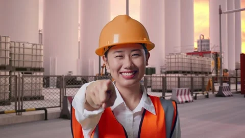 Female Engineer Touching Her Chest Then Pointing at Storage Facility Stock Footage 337754255