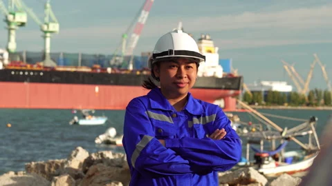 Female engineer in uniform and hard hat standing confidently at industrial port Video stock 342918272