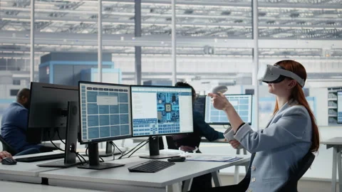 Female engineer uses VR glasses to examine microchip circuit layout in RD office Stock Footage 335880161