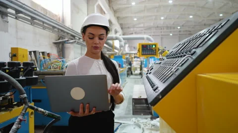 Female engineer using laptop and control panel in factory Stock Footage 314236446