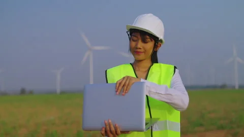 FEmale engineer using laptop at wind turbine farm. Vídeos de archivo 235550559
