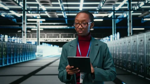 Female engineer walks in data center, using tablet and AR tech to monitor errors Stock Footage 329652255