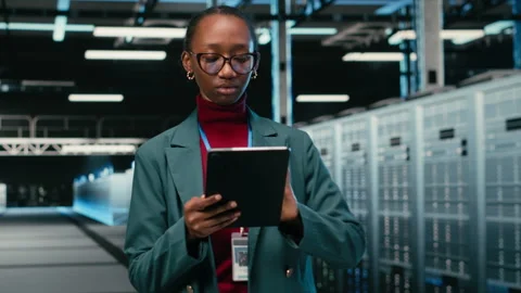 Female engineer walks in data center, using tablet and AR tech to monitor errors Stock Footage 329945121