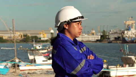 Female engineer in white helmet overseeing operations at busy harbor Video stock 342919793