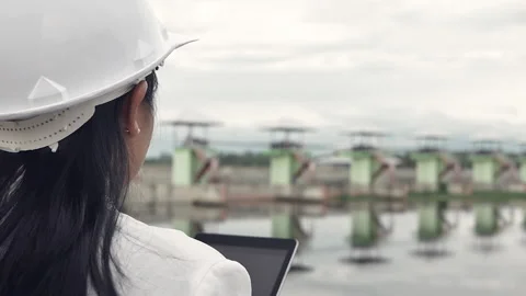 Female engineer in a white helmet working with a digital tablet at the dam. Stock Footage 156529158