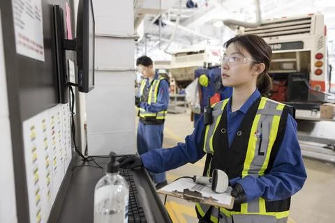 Female engineer working at computer in bus maintenance facility Stock Photos