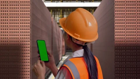 Female Engineer Working On A Green Screen Smartphone With Brick In Stacks Stock Footage 303762752