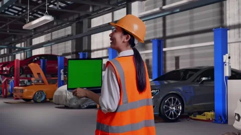 Female Engineer Working On A Green Screen Laptop in Auto Repair Shop Stock Footage 313528476