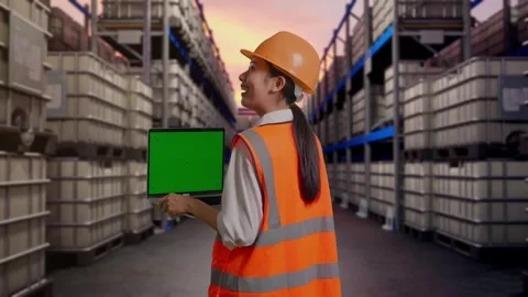 Female Engineer Working On A Green Screen Laptop at Fuel Warehouse Stock Footage 332156045