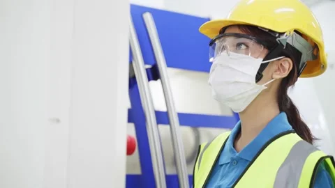 Female engineer working in industry looking and operating the machine. Stock Footage 147910698