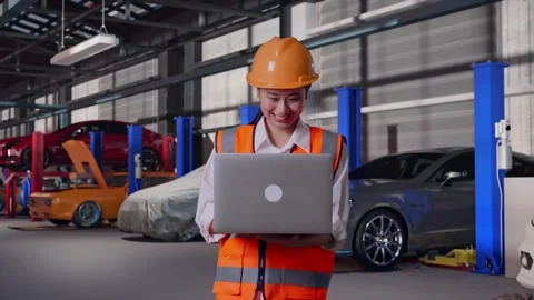 Female Engineer Working On A Laptop in Auto Repair Shop Stock Footage 313528027