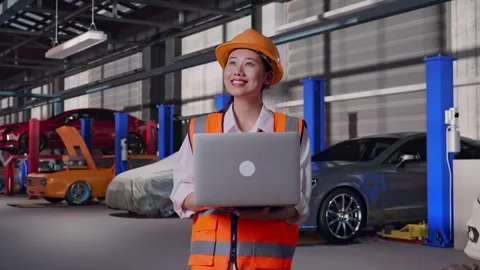 Female Engineer Working On A Laptop in Auto Repair Shop Stock Footage 313528029
