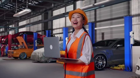 Female Engineer Working On A Laptop in Auto Repair Shop Stock Footage 313528274