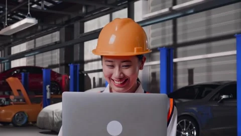 Female Engineer Working On A Laptop in Auto Repair Shop Stock Footage 313528859