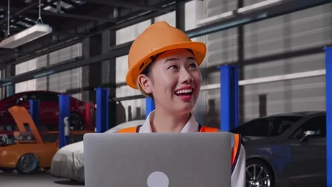 Female Engineer Working On A Laptop in Auto Repair Shop Stock Footage 313528862