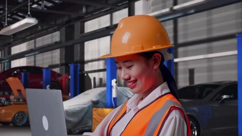 Female Engineer Working On A Laptop in Auto Repair Shop Stock Footage 313529059