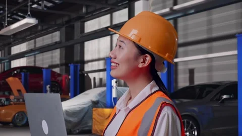 Female Engineer Working On A Laptop in Auto Repair Shop Stock Footage 313529062