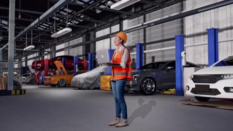 Female Engineer Working On A Laptop in Auto Repair Shop Stock Footage 313530370