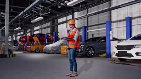 Female Engineer Working On A Laptop in Auto Repair Shop Stock Footage 313530388
