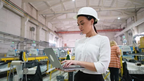 Female engineer working on laptop in pvc window factory Stock Footage 314581430
