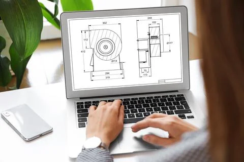 Female engineer working with technical drawing on laptop indoors, closeup Foto stock