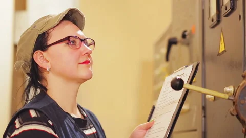 A female engineer writes down the readings of electrical appliances in the Stock Footage 105072001