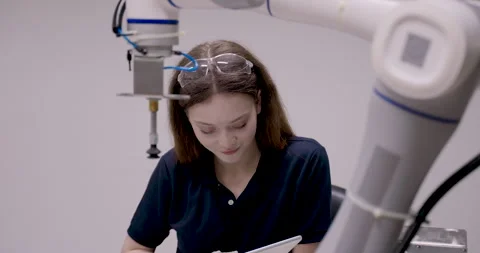 Female engineering student adjusts suction gripper with white glove during Stock Footage 326579701