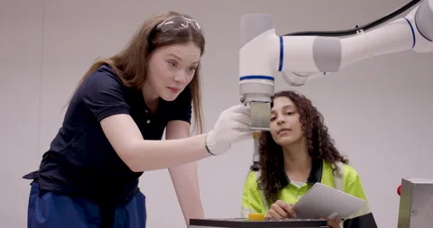 Female engineering student presenting robotic arm function to team during Vidéo 316077015