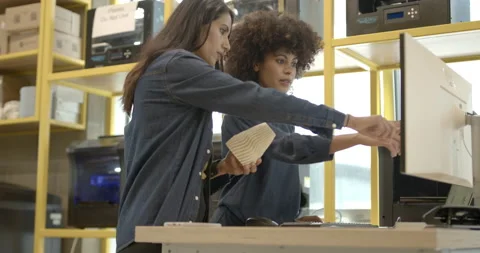 Female engineers in creative office looking at 3d printer and model Stock Footage 165081955
