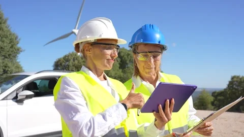 Female engineers working together in a wind turbine farm Stock Footage 344563841