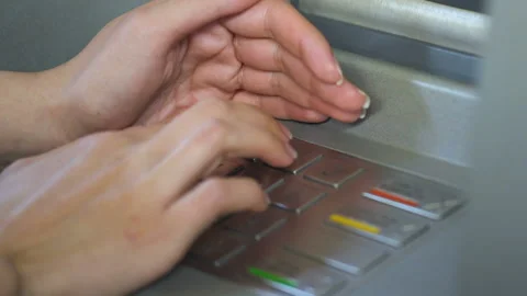 Female entering her pin code and hiding keyboard of automated teller machine Stock Footage 92602902
