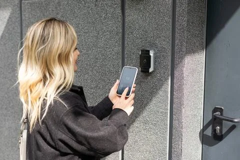 Female entering secret key code for getting access and passing building using 写真素材