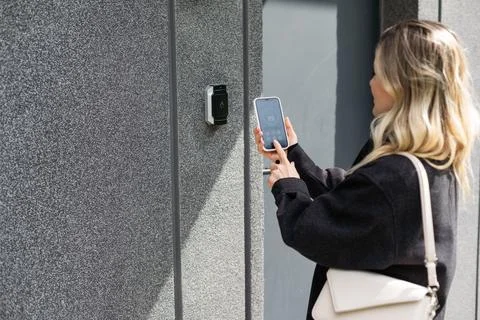 Female entering secret key code for getting access and passing building using Foto stock