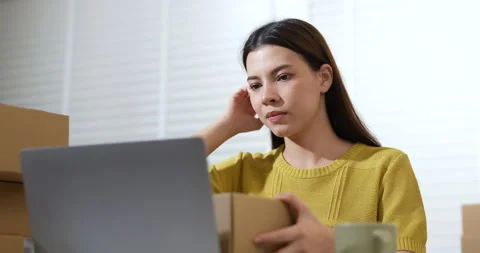 Female entrepreneur preparing parcel boxes for e-commerce shipment, checking Video stock 322043264