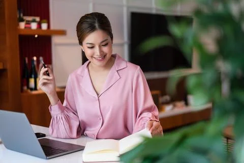 Female entrepreneur taking notes while thinking strategy about new startup .. Stock Photos