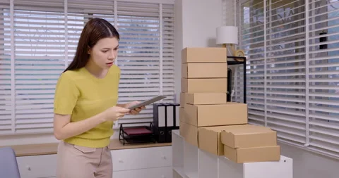 Female entrepreneur using tablet to check final e-commerce orders, celebrating Stock Footage 322043797