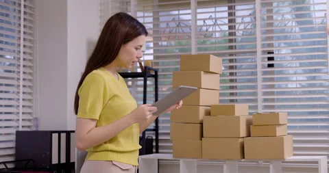 Female entrepreneur using tablet to track shipping orders, organizing parcel Stock Footage 330841810