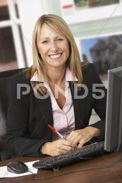 Female Estate Agent Working At Desk Stock Photos