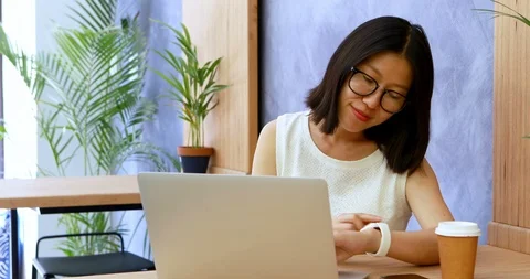 Female executive checking time on smartwatch while working at desk 4k Stock Footage 90713278