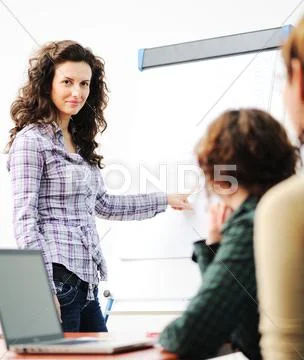 Female executive making presentation to her colleagues in modern enviroment Stock Photos