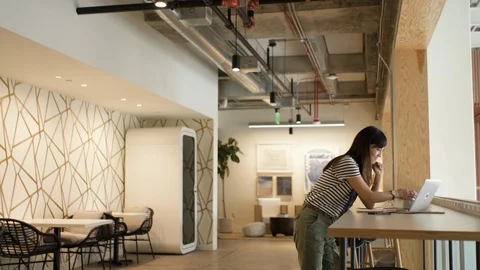 Female executive using laptop while having coffee in cafeteria Stock Footage 105614174