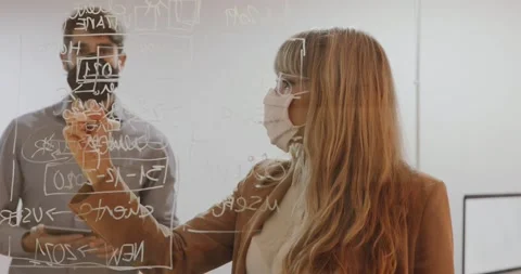 Female executive using mask presenting an idea to a coleague Stock Footage 143798392