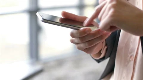 Female executive using smart phone by window in office Stock Footage 54990229